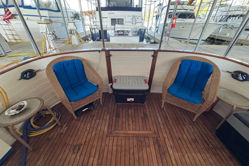 Slide: The Image of 1984 Kadey-Krogen 36 Manatee boat deck with wicker chairs and blue cushions. - 32