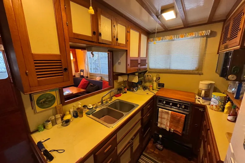 Slide: The Image of Cozy 1984 Kadey-Krogen 36 Manatee kitchen with wooden cabinets and compact appliances. - 53
