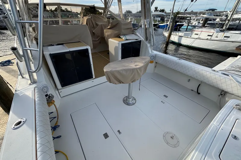 Slide: The Image of 2003 Carolina Classic 28 boat interior with covered seating and docked at marina. - 10