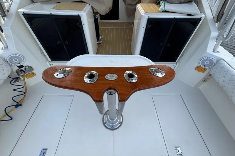 Slide: The Image of 2003 Carolina Classic 28 boat interior with wooden rod holder and seating area. - 11