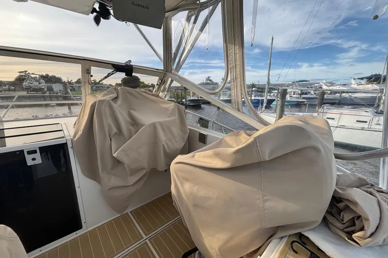 Slide: The Image of 2003 Carolina Classic 28 boat interior with covered seats at a marina. - 12