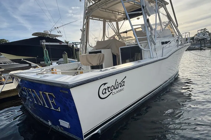 Slide: The Image of 2003 Carolina Classic 28 boat docked at marina, featuring sleek design and sturdy build. - 3