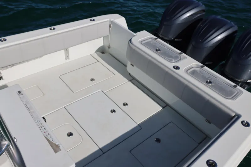 Slide: The Image of 2022 Contender 39 Fisharound boat deck with storage compartments and triple outboard motors. - 12