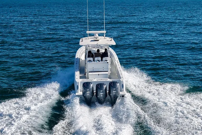 Slide: The Image of 2022 Contender 39 Fisharound cruising on open water with triple outboard engines. - 8