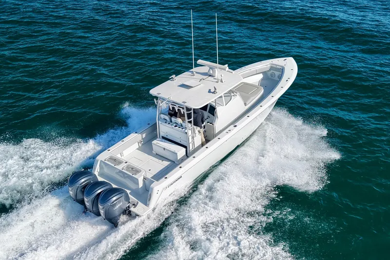 Slide: The Image of 2022 Contender 39 Fisharound boat cruising on open water with triple outboard engines. - 9