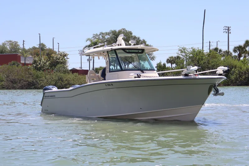 Slide: The Image of 2021 Grady-White Canyon 336 boat cruising on a sunny day near lush shoreline. - 11