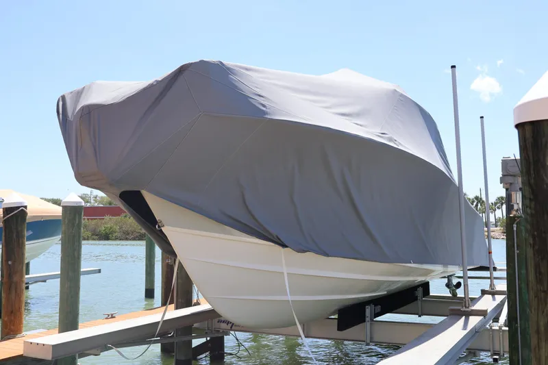Slide: The Image of 2021 Grady-White Canyon 336 boat covered on a lift at a marina. - 13