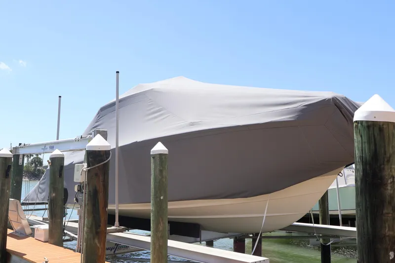 Slide: The Image of 2021 Grady-White Canyon 336 boat covered and docked on a lift. - 14