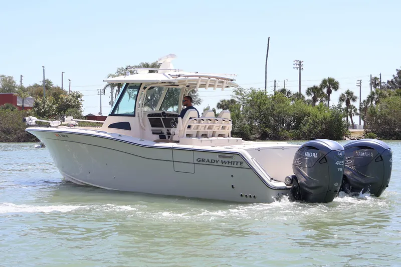 Slide: The Image of 2021 Grady-White Canyon 336 boat cruising on water with twin Yamaha engines. - 4