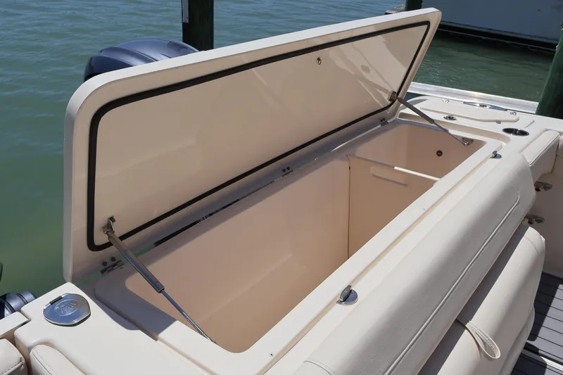 Slide: The Image of Open storage compartment on 2021 Grady-White Canyon 336 boat, docked by water. - 47