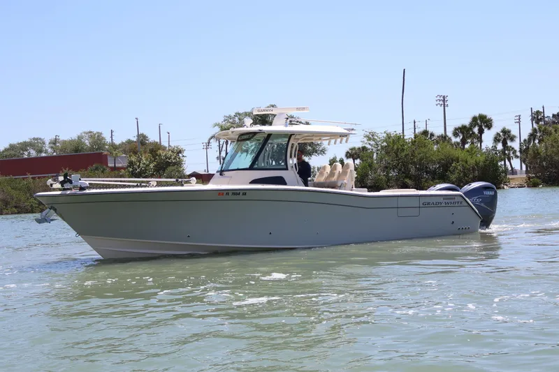 Slide: The Image of 2021 Grady-White Canyon 336 boat on calm water, featuring twin Yamaha engines. - 9
