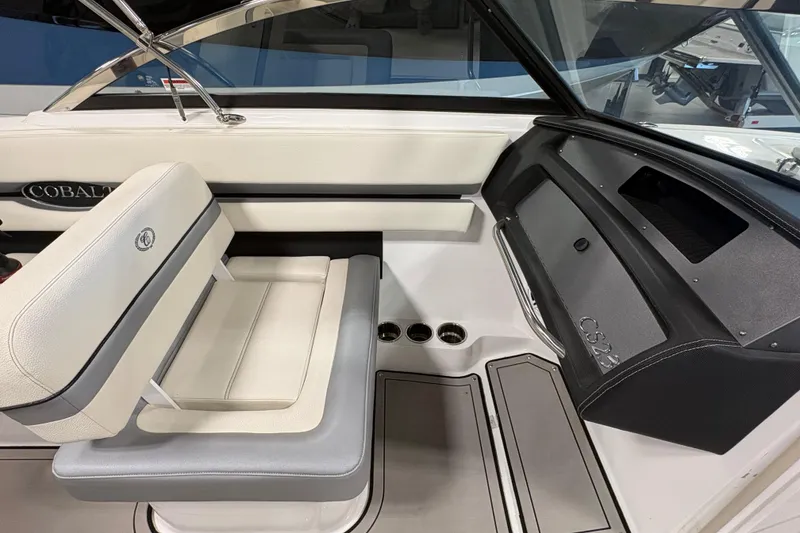 Slide: The Image of 2021 Cobalt CS23 boat interior with white seating and dashboard details. - 14