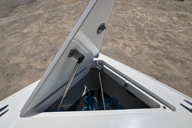 Slide: The Image of Open storage compartment on 2021 Cobalt CS23 boat, revealing anchor and rope. - 16