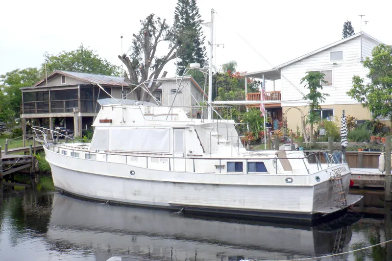 The Image of 1980 Grand Banks 49 Classic yacht docked near waterfront homes. - 0