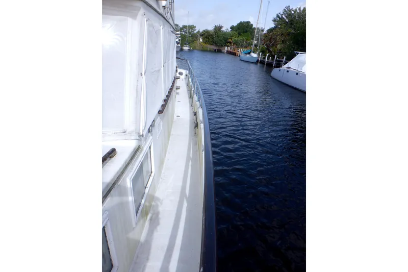 Slide: The Image of Side view of a 1980 Grand Banks 49 Classic yacht on a calm waterway. - 15