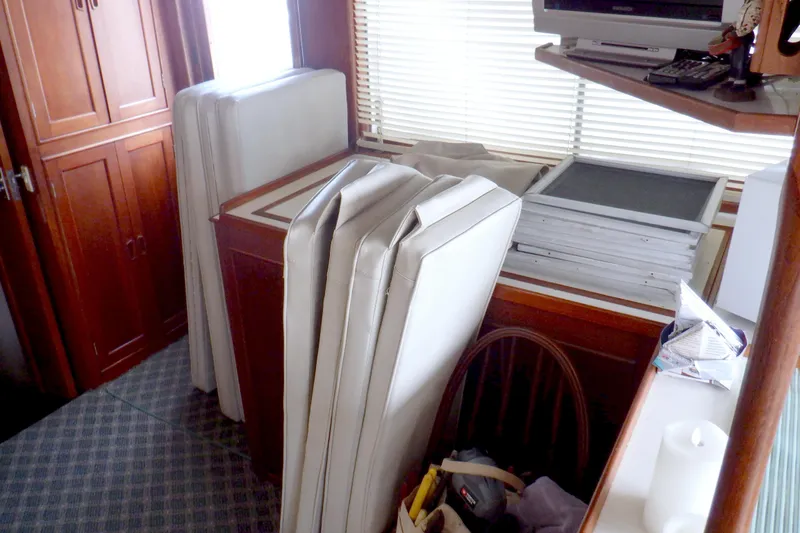 Slide: The Image of Interior of 1980 Grand Banks 49 Classic with stacked cushions and wooden cabinetry. - 17