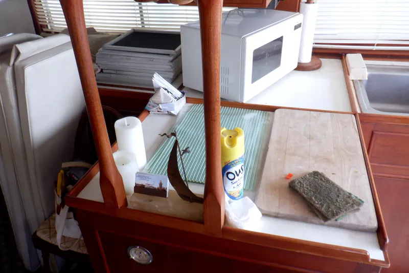 Slide: The Image of Interior of 1980 Grand Banks 49 Classic with kitchen counter, microwave, and cleaning supplies. - 18