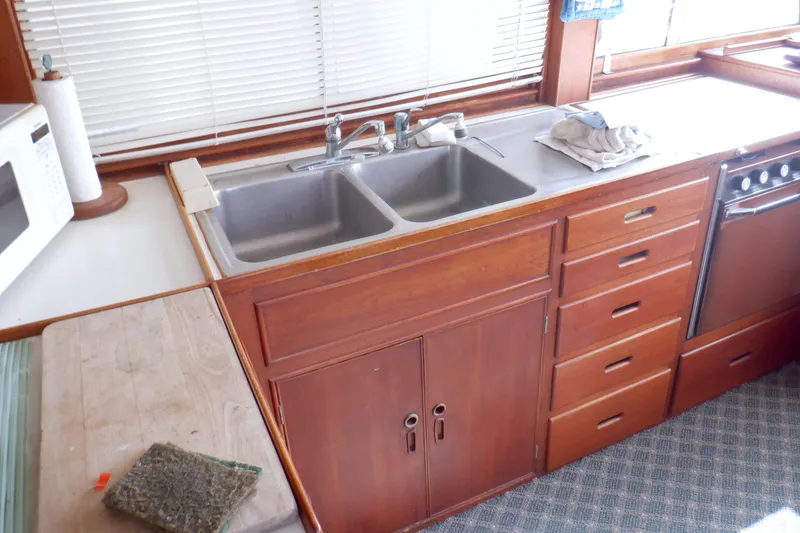 Slide: The Image of Kitchen area of a 1980 Grand Banks 49 Classic yacht with wooden cabinetry and double sink. - 19