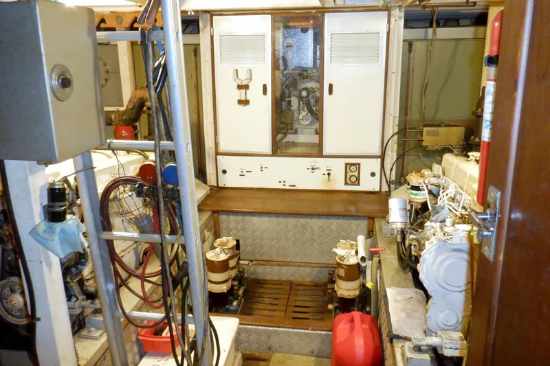 Slide: The Image of Engine room of a 1980 Grand Banks 49 Classic yacht, featuring mechanical equipment and controls. - 42