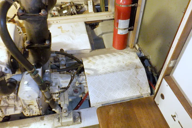 Slide: The Image of Engine room of 1980 Grand Banks 49 Classic with fire extinguisher and mechanical components. - 52