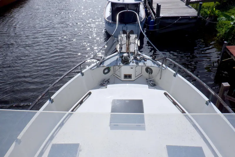 Slide: The Image of 1980 Grand Banks 49 Classic yacht docked, viewed from the bow, with calm water reflections. - 6