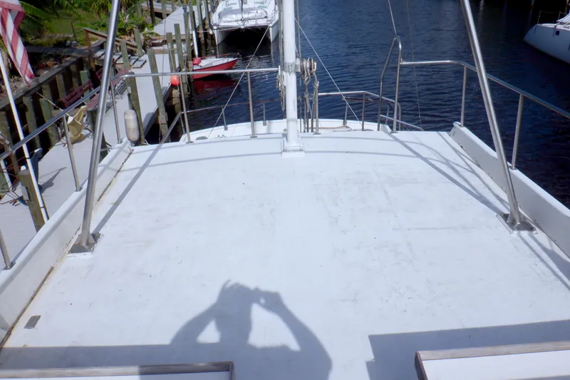 Slide: The Image of 1980 Grand Banks 49 Classic yacht deck with railing, docked by the water. - 7