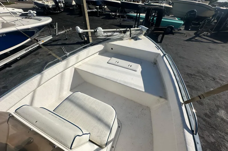 Slide: The Image of 2004 Palm Beach 161 Whitecap boat deck with seating, parked among other boats. - 2