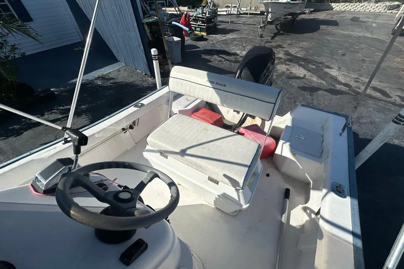 Slide: The Image of 2004 Palm Beach 161 Whitecap boat interior with steering wheel and seating. - 5