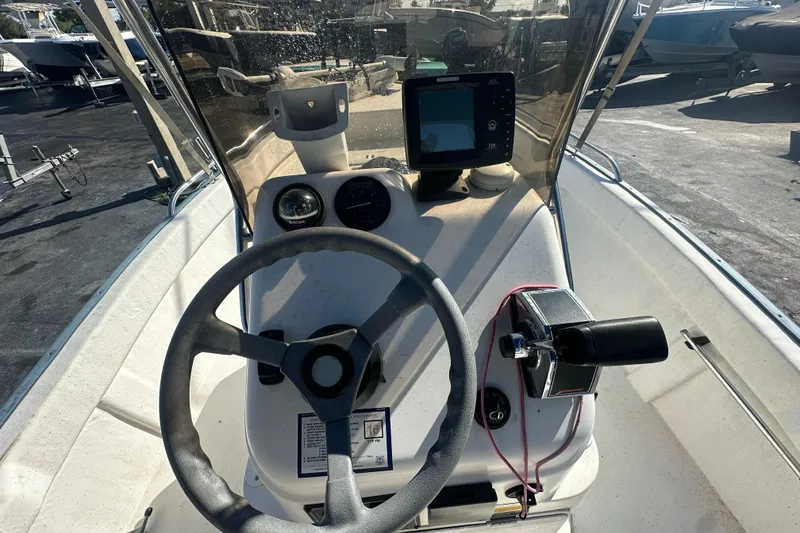 Slide: The Image of 2004 Palm Beach 161 Whitecap boat dashboard with steering wheel and navigation equipment. - 7
