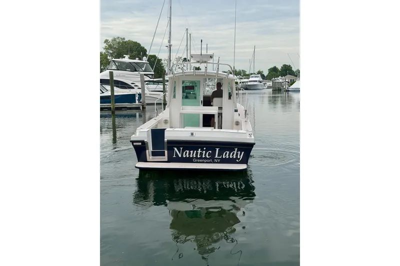 Slide: The Image of 2006 Albin 28 Tournament Express boat named "Nautic Lady" in a marina setting. - 18