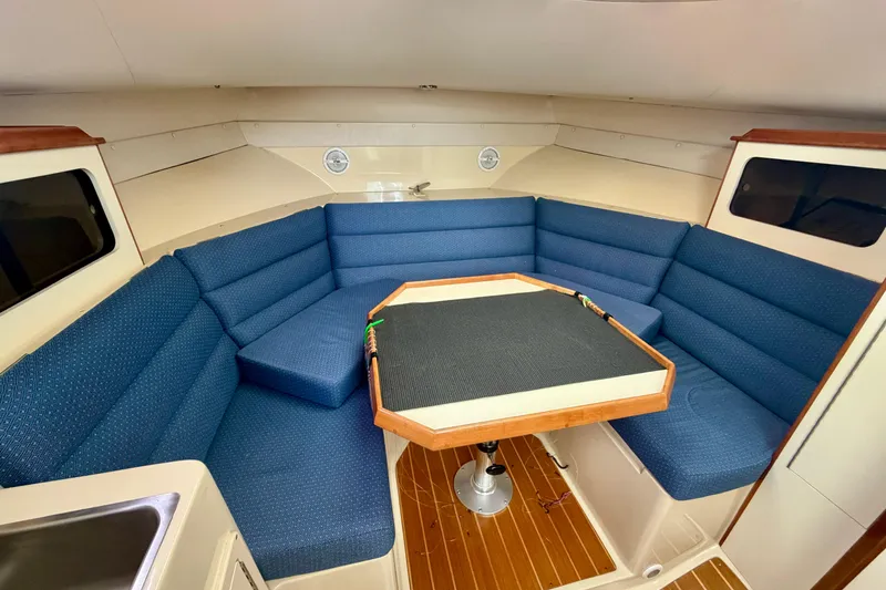 Slide: The Image of Interior of 2006 Albin 28 Tournament Express with blue seating and wooden table. - 19