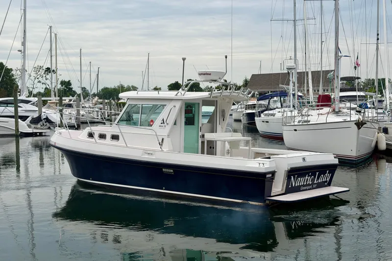 Slide: The Image of 2006 Albin 28 Tournament Express boat docked in a marina, surrounded by other vessels. - 2
