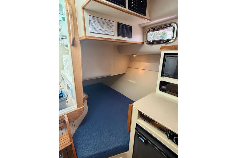 Slide: The Image of 2006 Albin 28 Tournament Express cabin interior with blue seating and wooden accents. - 20