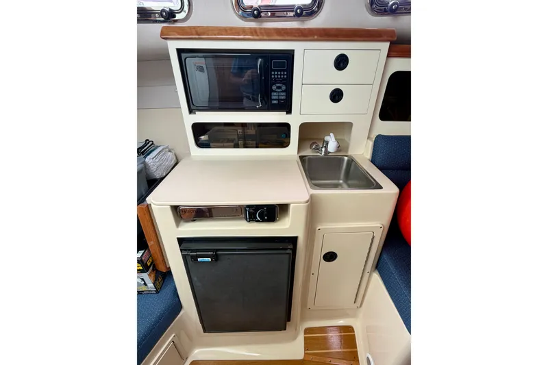 Slide: The Image of Compact galley in 2006 Albin 28 Tournament Express with microwave, sink, and mini-fridge. - 22
