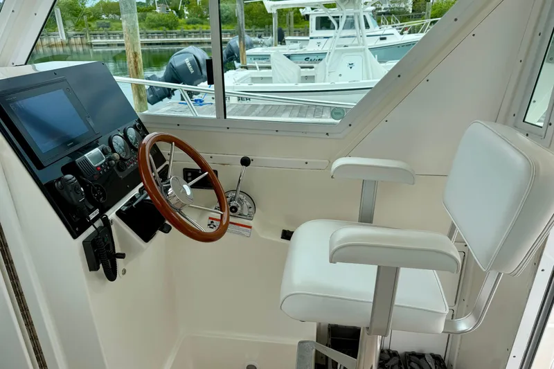 Slide: The Image of 2006 Albin 28 Tournament Express helm with steering wheel and navigation controls. - 25