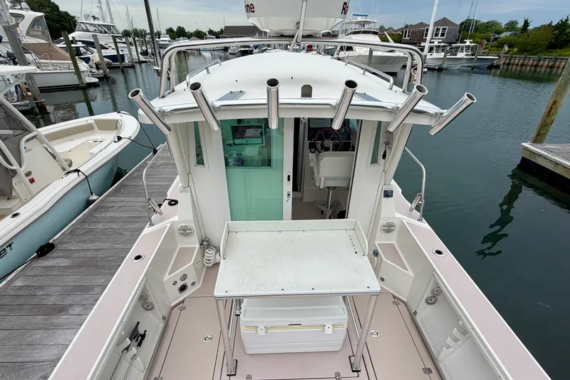 Slide: The Image of 2006 Albin 28 Tournament Express boat docked at a marina, featuring fishing rod holders. - 35