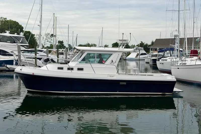 Slide: The Image of 2006 Albin 28 Tournament Express boat docked in a marina, surrounded by other vessels. - 6