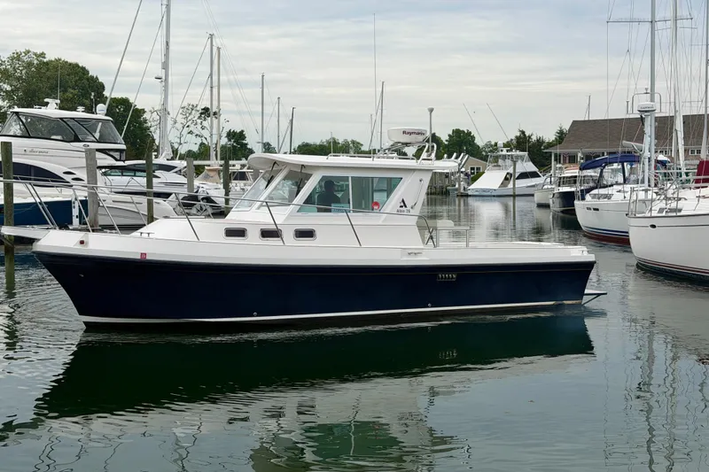 Slide: The Image of 2006 Albin 28 Tournament Express boat docked in a marina with other vessels. - 7