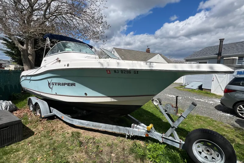 The Image of 2007 Seaswirl Striper 2301 Dual Console O/B boat on trailer, parked outdoors. - 0