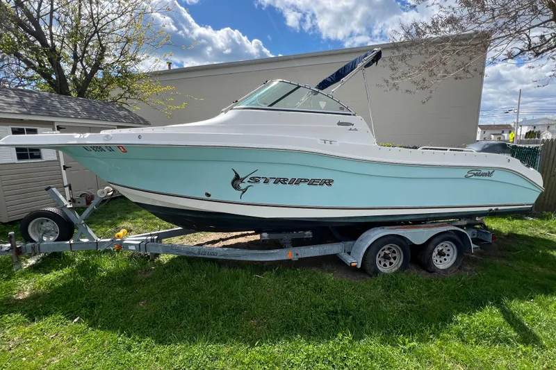 Slide: The Image of 2007 Seaswirl Striper 2301 Dual Console O/B boat on trailer, parked on grass. - 1