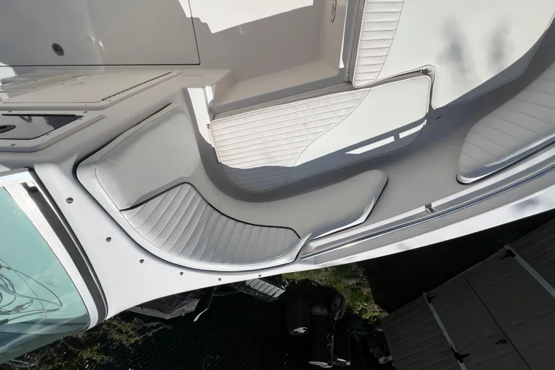 Slide: The Image of 2007 Seaswirl Striper 2301 Dual Console O/B interior seating area, featuring white cushioned seats. - 7