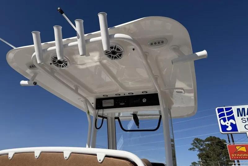 Slide: The Image of 2026 Sea Hunt Gamefish 27 boat top with rod holders and speakers against blue sky. - 16