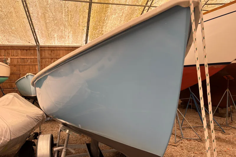 Slide: The Image of 1971 Rhodes 19 sailboat in storage, showcasing its sleek blue hull. - 10
