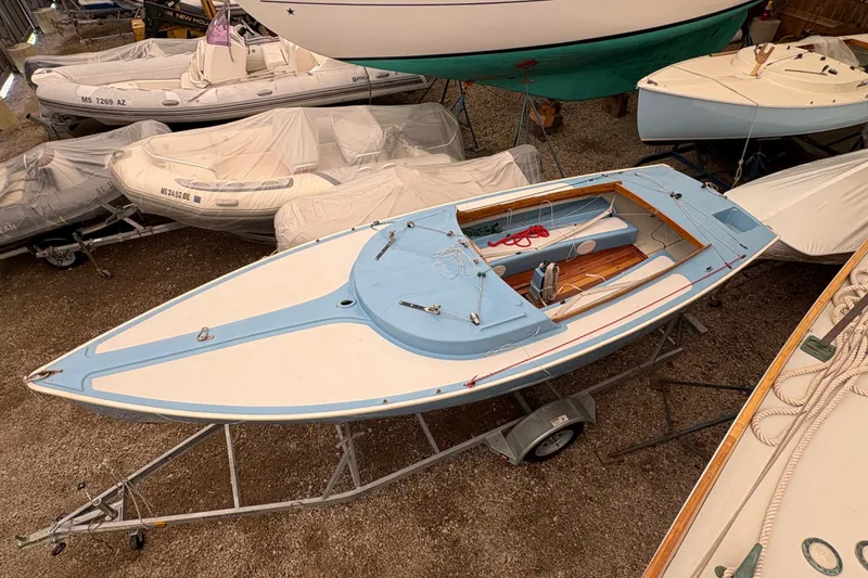 Slide: The Image of 1971 Rhodes 19 sailboat on trailer in storage, surrounded by covered boats. - 3