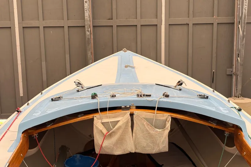 Slide: The Image of 1971 Rhodes 19 sailboat bow with rigging details, docked indoors. - 5