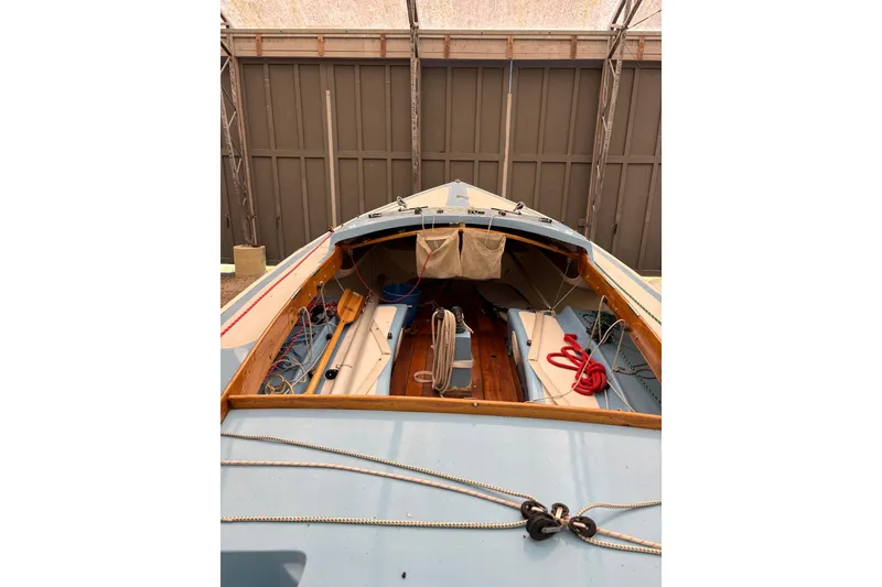 Slide: The Image of 1971 Rhodes 19 sailboat interior with ropes and wooden deck in storage. - 6