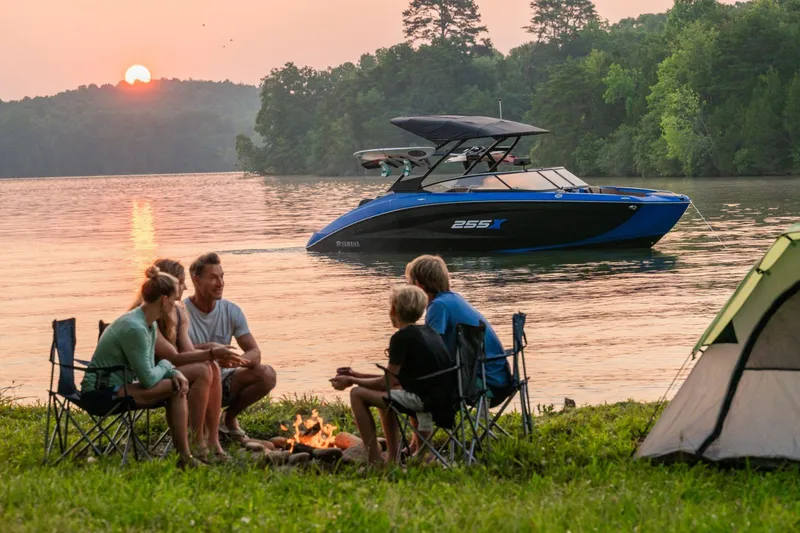 Slide: The Image of Family camping by lake with 2026 Yamaha Boats 255XD at sunset. - 1