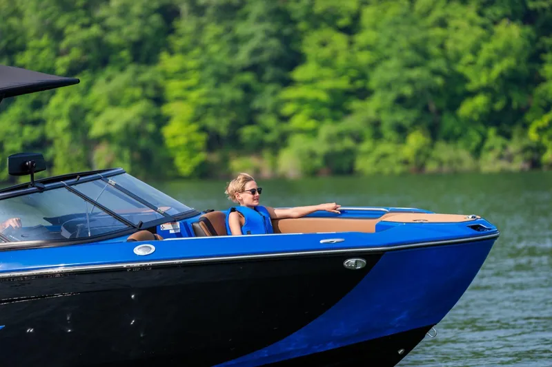 Slide: The Image of 2026 Yamaha Boats 255XD on water, person relaxing in blue life jacket. - 10