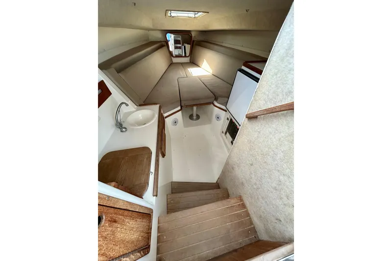 Slide: The Image of 2001 Contender 35 Side Console cabin interior with sink, seating, and wooden steps. - 12