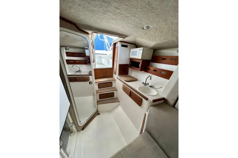 Slide: The Image of 2001 Contender 35 Side Console interior with sink, seating, and wooden accents. - 13